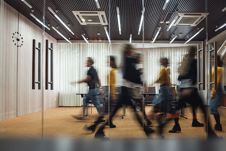 Motion blur image of people walking in office