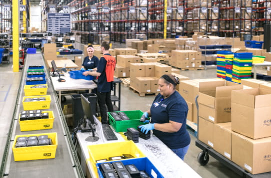 Employees load orders in a warehouse